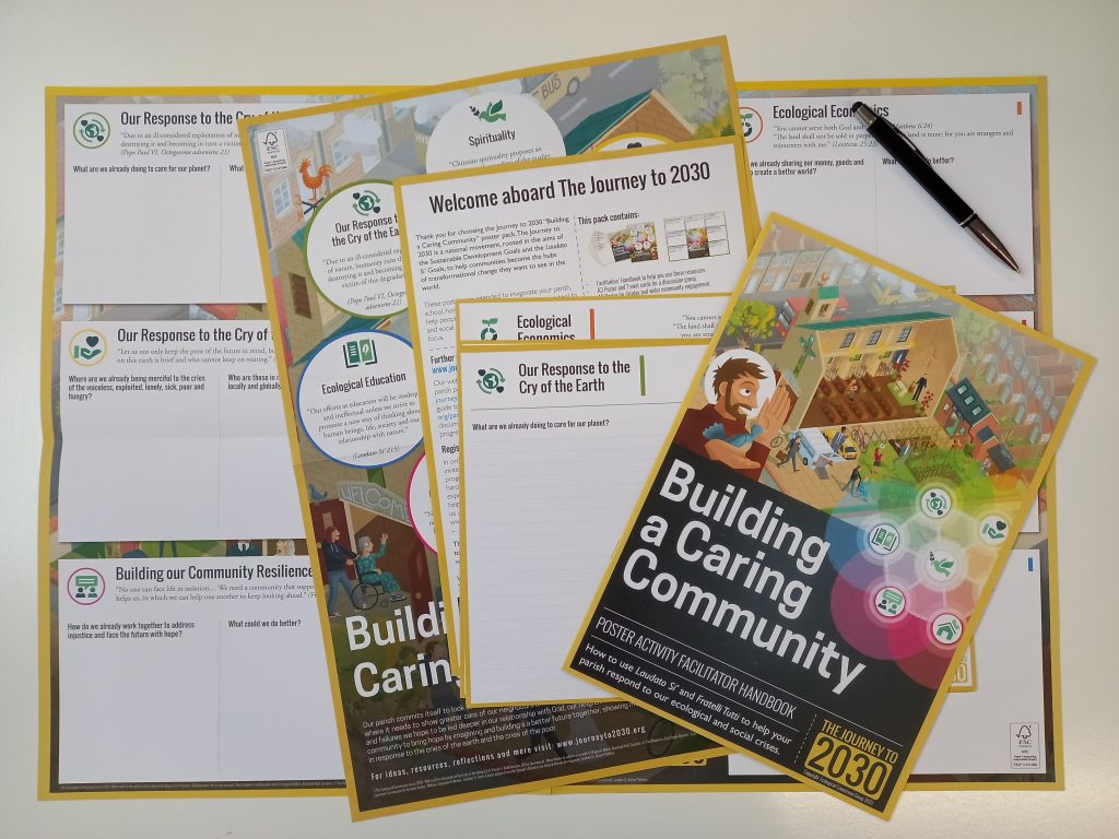 a set of papwe resources spread over a white table with the booklet called building a caring community on top of the pile